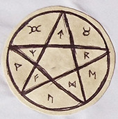 One of my old talismans, stuck into my book of shadows. It's a pentacle and the spaces are filled with runes.